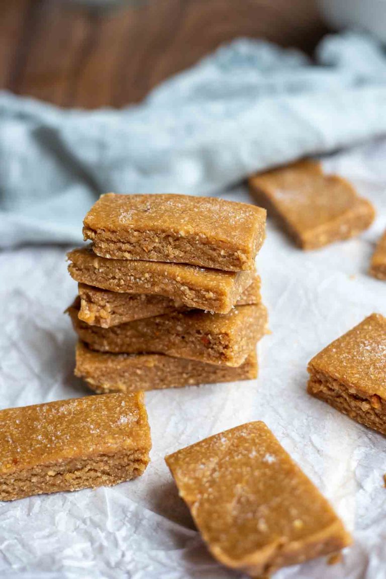 stack of low fodmap protein bars on parchment paper with 5 more bars around the stack