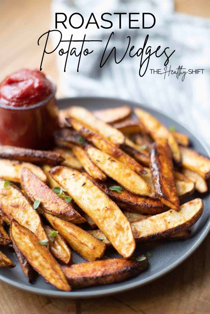 roasted potato wedges on dark gray plate with low fodmap ketchup on the side of plate