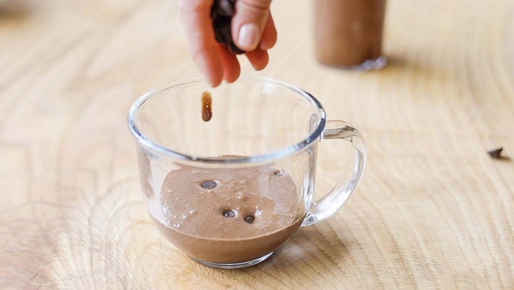 adding chocolate chips on mug batter