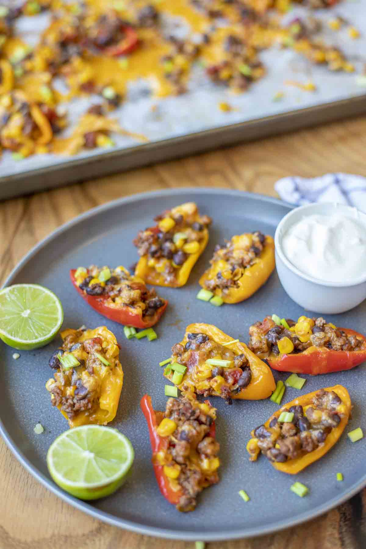 spread out above view of mini pepper nachos with lime and sour cream